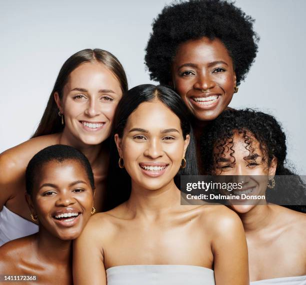 ritratto di donne di bellezza diverse e luminose che si sentono sicure e soddisfatte della loro routine di cura della pelle. diverse femmine con volti radiosi e atteggiamenti positivi su uno sfondo grigio - different nationalities foto e immagini stock