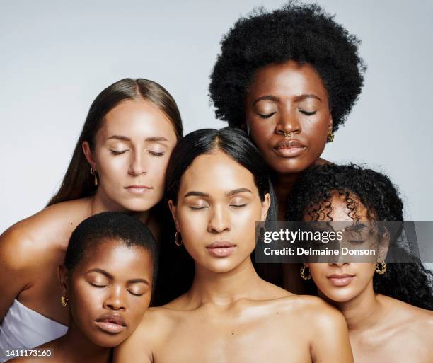 diverse women with glowing skin and natural makeup on studio background. group of international beauty models looking flawless, clean and radiant. multicultural female posing for hygiene and skincare - portrait dark background stock pictures, royalty-free photos & images