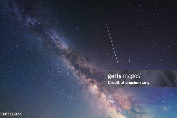 meteor streaks across the milky way - astrophysics fotografías e imágenes de stock