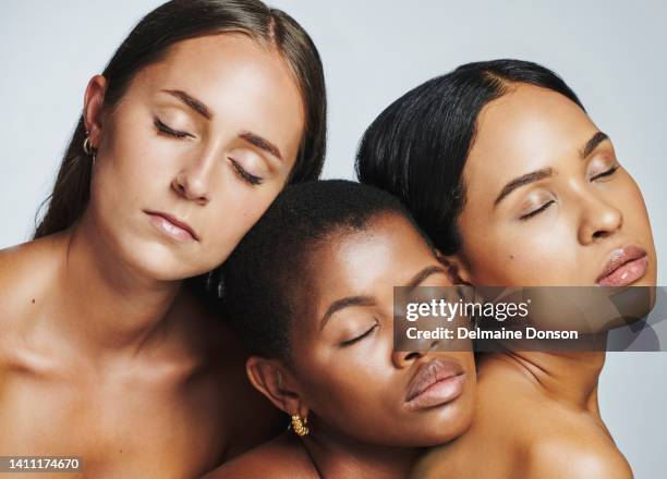 a diverse group of beautiful women huddled together against a white studio background. faces of female models showing their perfect, clear skin and complexion from a daily skincare and beauty routine - perfect complexion stock pictures, royalty-free photos & images