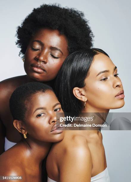 international women with radiant, soft skin and neutral makeup. multicultural females posing for hygiene, body and skincare. group of beautiful, diverse girls looking flawless on studio background - portrait dark background stock pictures, royalty-free photos & images