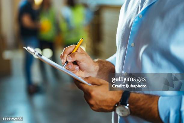 hombre adulto escribiendo en el portapapeles en el patio de embarque - calidad fotografías e imágenes de stock