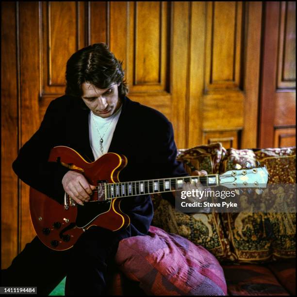 British musician, songwriter, and producer Mike Oldfield plucking a Gibson guitar, Berkshire, UK, 16th March 1993.