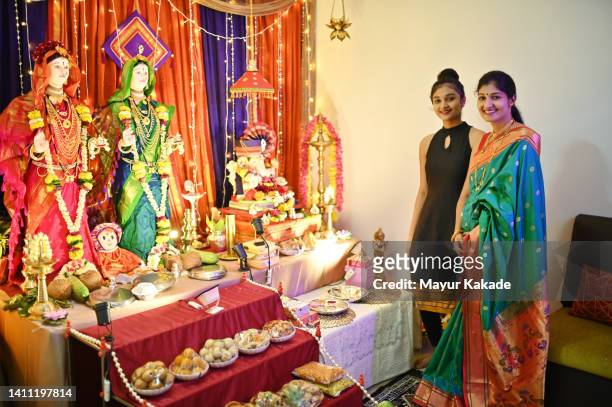 mother and teenage daughter standing next to ganesha idol decoration - ganesh chaturthi fotografías e imágenes de stock