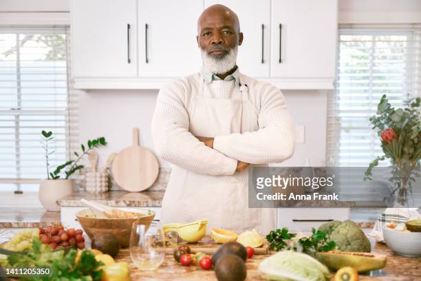 portrait of a serious man standing in the kitchen - black chef stock pictures, royalty-free photos & images