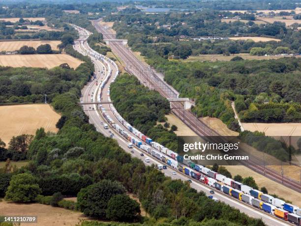 An aerial view of lorries waiting in a queue on the M20 motorway on July 22,2022 in Ashford, Kent. The Port of Dover declared a “critical incident”...
