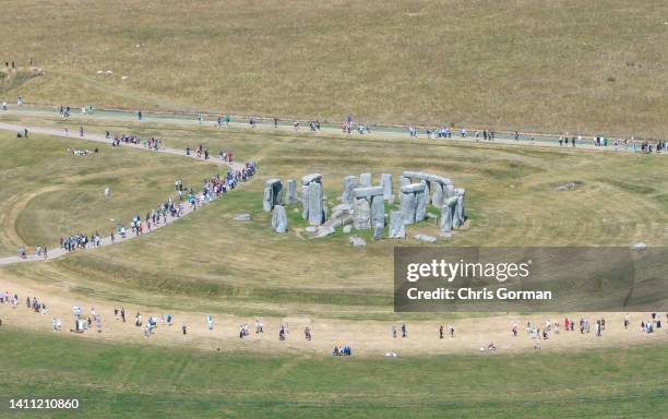 An aerial view of visitors at Stonehenge on July 14, 2022 in Wiltshire, England. Usually grass-covered, the heat has seen the grass dry. Britain will...