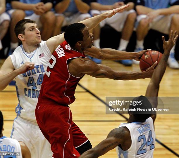 North Carolina State guard Lorenzo Brown splits between North Carolina forward Tyler Zeller and guard Justin Watts to score in the first half of a...