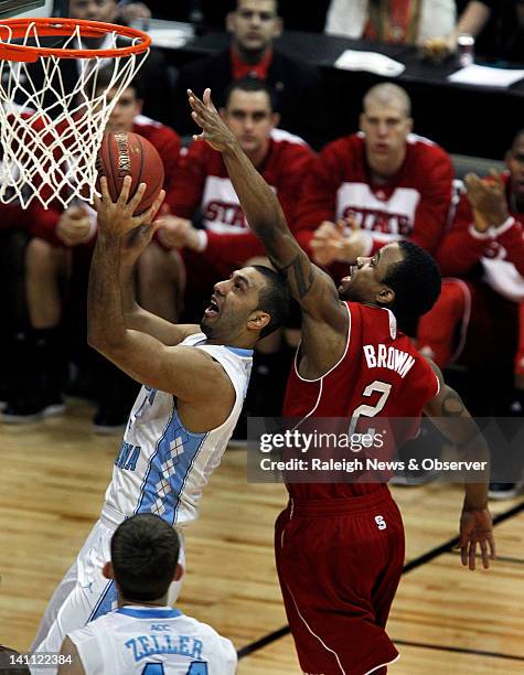 North Carolina guard Kendall Marshall goes in for a shot as North Carolina State guard Lorenzo Brown defends during the first half of a semifinal at...