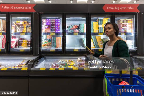 browsing in the frozen section - supermarket freezer stock pictures, royalty-free photos & images