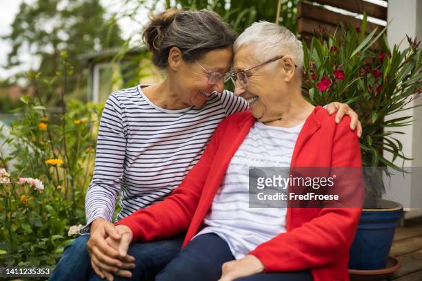 seniorin mit pflegekraft im garten - caregiver elderly stock-fotos und bilder