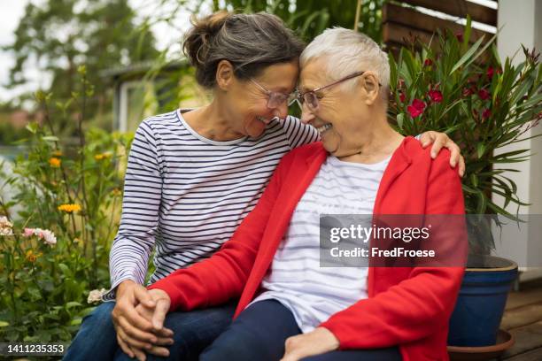 mujer mayor con cuidador en el jardín - humanidad fotografías e imágenes de stock