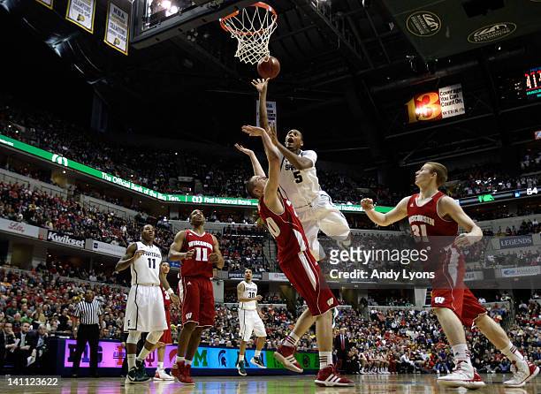 Adreian Payne of the Michigan State Spartans drives for a shot attempt against Jared Berggren of the Wisconsin Badgers during their Semifinal game of...