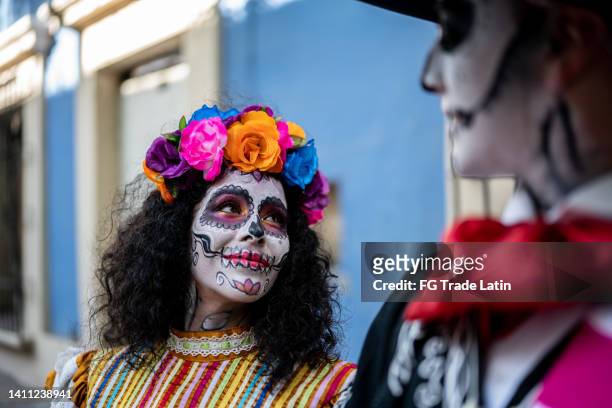 couple celebrating the day of the dead with makeup and traditional clothing - sugar skull stockfoto's en -beelden