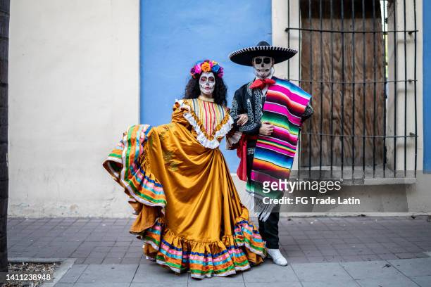 portrait of a couple celebrating the day of the dead with makeup and traditional clothing - la catrina stockfoto's en -beelden