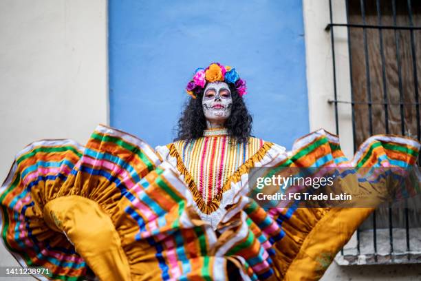 retrato de una mujer medianamente adulta bailando y celebrando el día de los muertos - custom fotografías e imágenes de stock