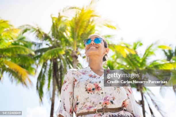 low angle view of a smiley woman in a tropical beach - coconut beach woman stock pictures, royalty-free photos & images