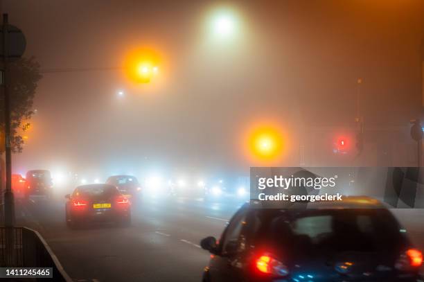 foggy road conditions at night - driving in fog stock pictures, royalty-free photos & images