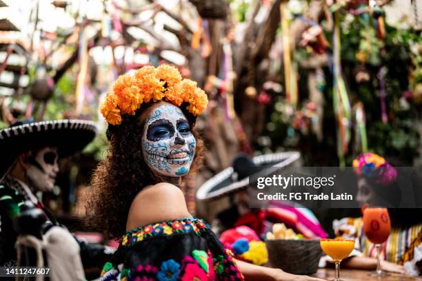 porträt einer jungen frau, die den tag der toten in der bar feiert - day of the dead stock-fotos und bilder