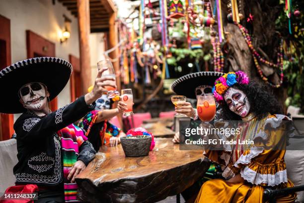 retrato de amigos haciendo un brindis de celebración el día de muertos en el bar - catrina mexico fotografías e imágenes de stock