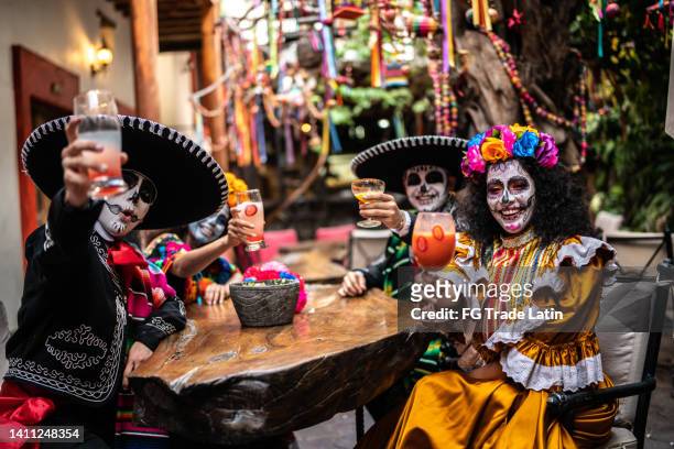 portrait of friends doing a celebratory toast on the day of the dead at bar - ceremony imagens e fotografias de stock