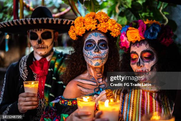 retrato de una joven celebrando el día de muerto encendiendo vela - catrina mexico fotografías e imágenes de stock