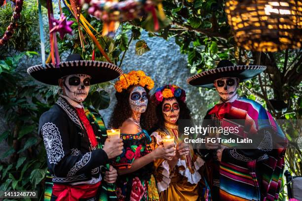 portrait of a friends celebrating the day of the dead lighting candle - méxico stock pictures, royalty-free photos & images