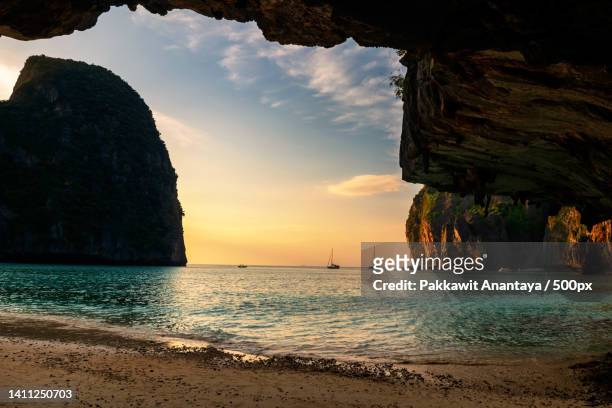 stone arch cave at maya beach at sunset near koh phi phi island,phi phi islands,krabi,thailand - phi phi islands stock pictures, royalty-free photos & images
