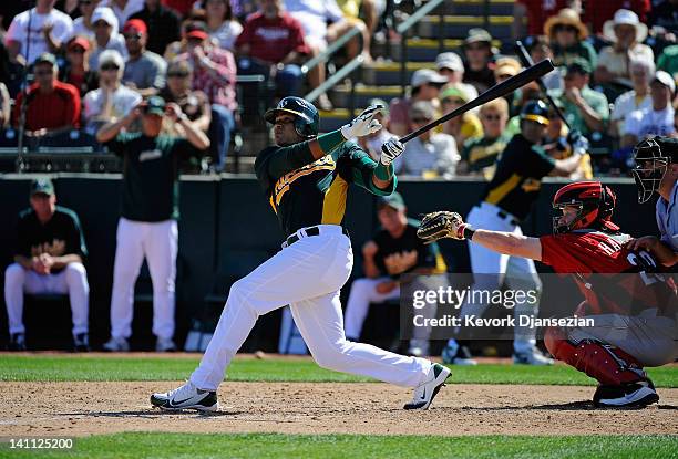 Yoenis Cespedes of the Oakland Athletics hits his first home run of the spring against the Cincinnati Reds during a spring training baseball game at...