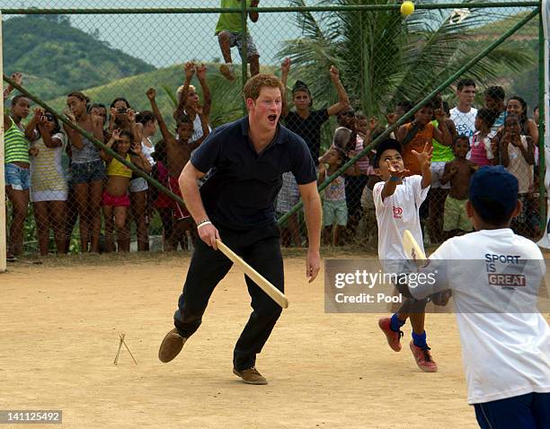 Children watch Prince Harry play cricket during a visit to the Favela on March 10, 2012 in Rio De Janeiro, Brazil. Prince Harry is in Brazil as part...