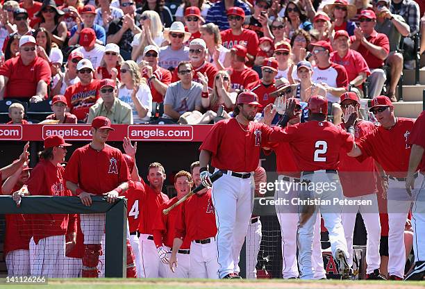 Erick Aybar of the Los Angeles Angels of Anaheim high-fives Bobby Wilson after scoring a run against the San Francisco Giants during the first inning...