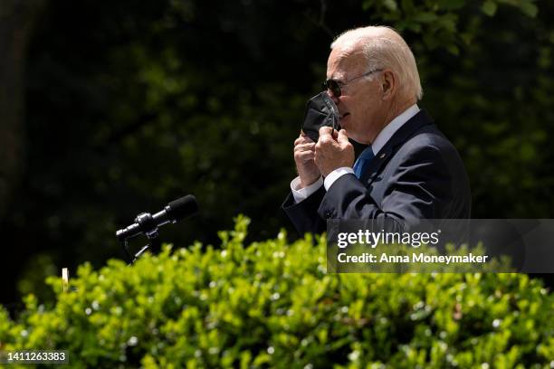President Joe Biden takes off a mask as he enters the Rose Garden to deliver remarks on COVID-19 at the White House on July 27, 2022 in Washington,...