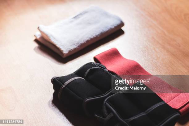 resistance band, towel and ankle weights on the floor. - ankle weights stock pictures, royalty-free photos & images