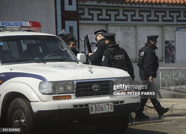 Armed Chinese police get ready to patrol a street in the county town of Banma in China's northwest Qinghai province on March 10, 2012. Chinese...