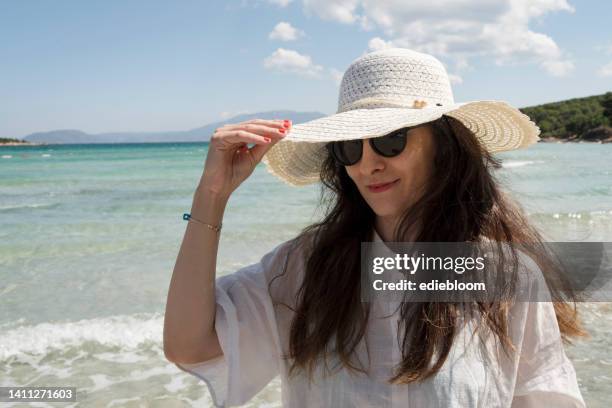 woman with beach hat and sunglasses - sun protection stock pictures, royalty-free photos & images