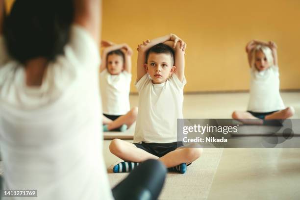 schüler, die beim training in der schule die hände ausstrecken - child mental health wellness stock-fotos und bilder