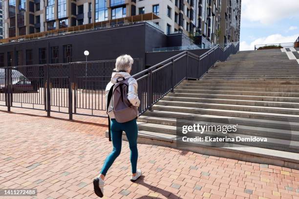 unrecognizable woman walking on street with staircase - russian mature women 個照片及圖片檔