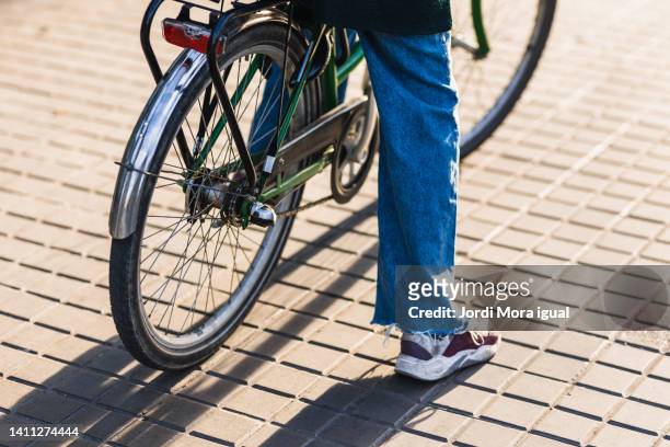 unrecognizable person riding bicycle on sidewalk on a sunny summer day. - bike pedal stock pictures, royalty-free photos & images