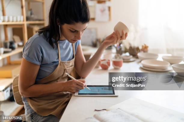 female artist drawing new desing of pottery products on digital tablet - earthenware stock pictures, royalty-free photos & images