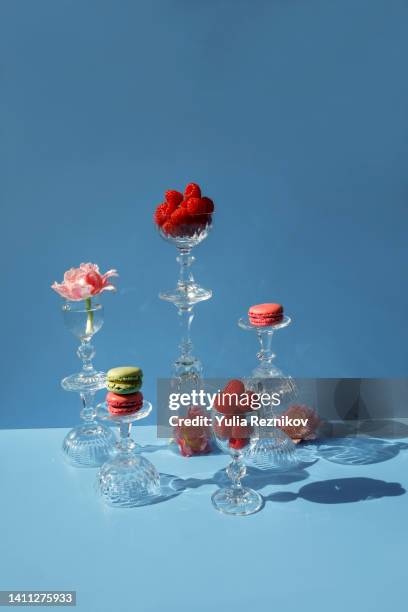 close-up of macarons and pink flowers on the blue background - dessert lifestyle stock pictures, royalty-free photos & images