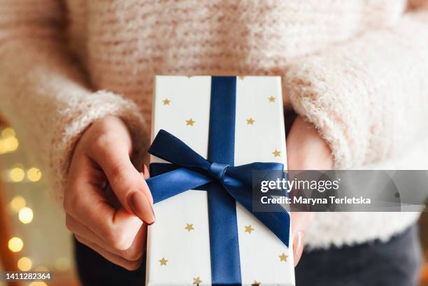 gift box in female hands. new year. christmas. gift. - wrapping arm stock pictures, royalty-free photos & images