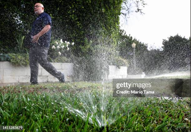 Los Angeles Department of Water and Power water conservation specialist Damon Ayala walks while inspecting a sprinkler system, which is operating in...