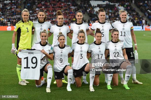 Giulia Gwinn of Germany holds up the jersey of teammate Klara Bühl who misses the match following a positive COVID-19 test as German players pose for...