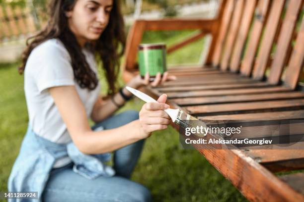 präzise pinselarbeit von female painting bench - holzbank stock-fotos und bilder