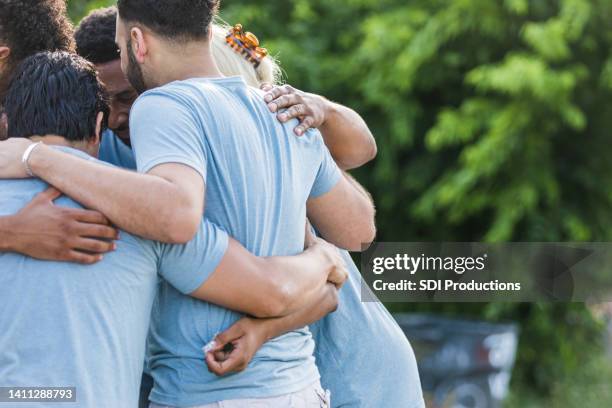 off center photo of group hugging - volunteers stock pictures, royalty-free photos & images