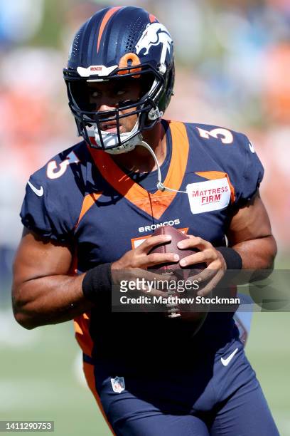 Quarterback Russell Wilson of the Denver Broncos practices with his team during training camp at UCHealth Training Center on July 27, 2022 in...