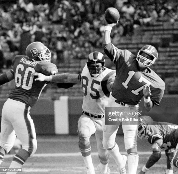 Denver Broncos QB Steve DeBerg under heavy pressure by Los Angeles Rams Jack Youngblood during game, December 12, 1982 in Anaheim, California.