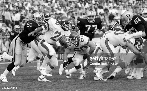New York Jets RB Freeman McNeil looks for running room as Raiders Ted Hendricks , Lyle Alzado and Bob Nelson converge during AFC Playoff game,...