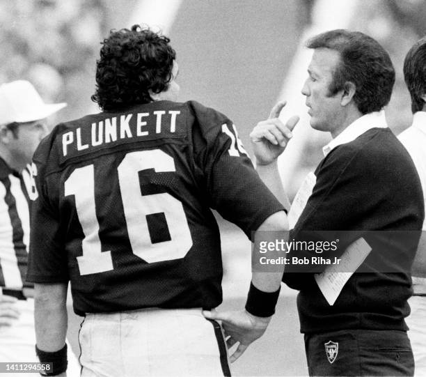 Raiders QB Jim Plunkett talks with Raiders Head Coach Tom Flores during AFC Playoff game, January 15, 1983 in Los Angeles, California.