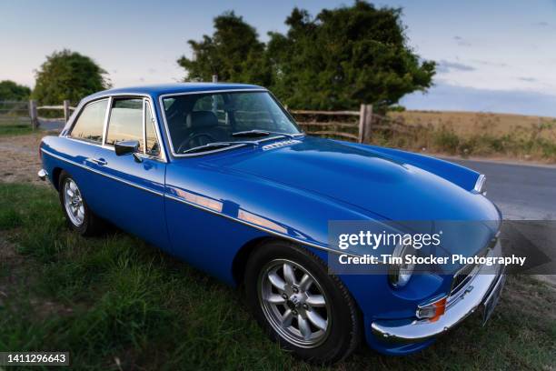 classic british car parked in country lane - collector's car stock-fotos und bilder